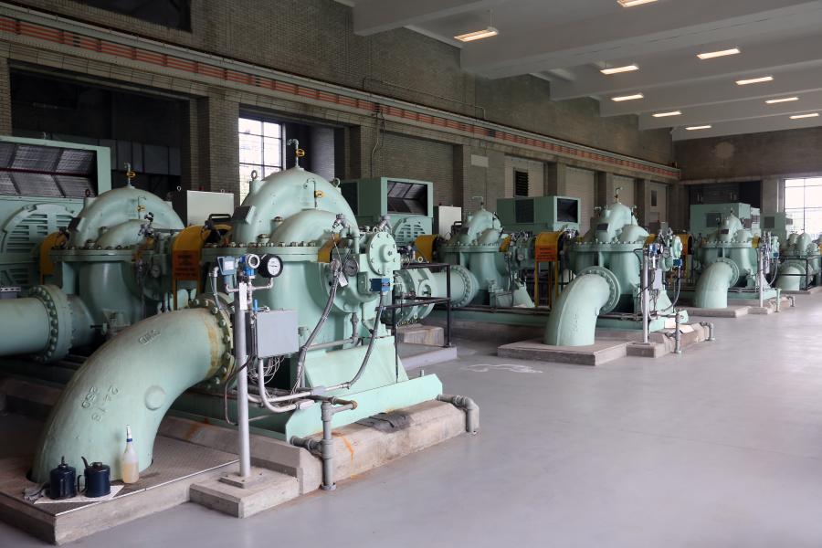 Three large water pumps inside a pump building