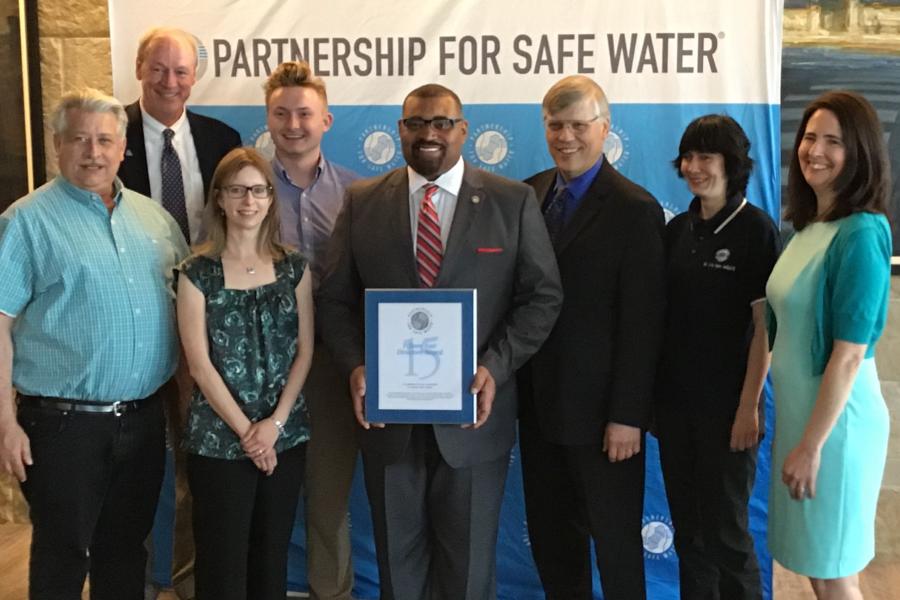A group of Cleveland Water employees pose together with an award