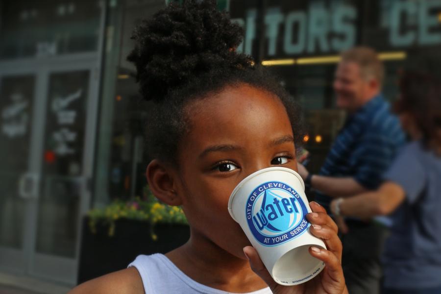 A young girl drinking from a Cleveland Water cup
