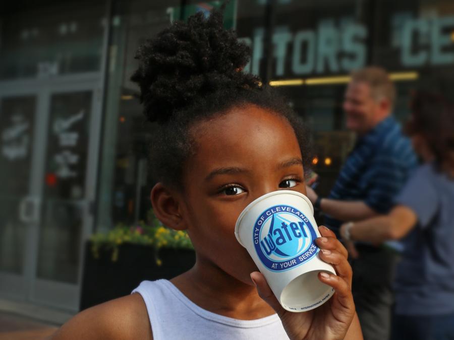 A young girl drinking from a Cleveland Water cup
